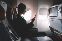 Silhouette Of Female Person Watching Online Video On Cellular Phone During Business Trip  Enjoying Comfortable Seat On Board And Good Wifi Connection For Browsing Internet.Airplane Passenger Using App