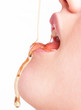 © bluebeat76 - Woman dripping honey on her tongue