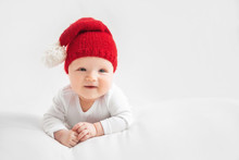 Christmas Portrait Of Cute Little Newborn Baby Boy, Wearing Santa Hat And Little Cute Snowman Toy, Studio Shot, Winter Time