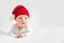 Christmas Portrait Of Cute Little Newborn Baby Boy, Wearing Santa Hat And Little Cute Snowman Toy, Studio Shot, Winter Time