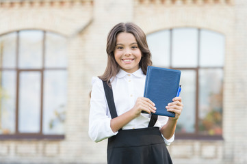 With library you are free. Happy small child hold library book with blue cover. Adorable little girl borrow books in school library. Library and bibliopole. Books and information. Knowledge day