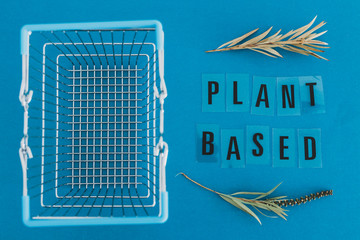 shopping basket with leaves and Plant-based text metaphor of vegan and eco-friendly products and diet