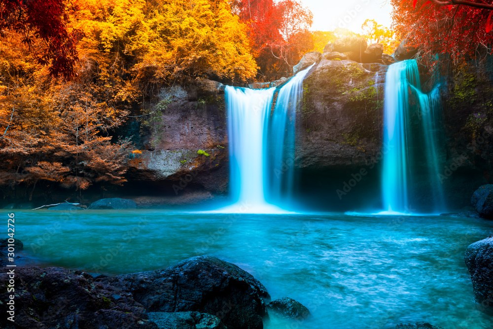 The amazing colorful waterfall in autumn forest blue water and colorful rain forest. - obrazy, fototapety, plakaty 