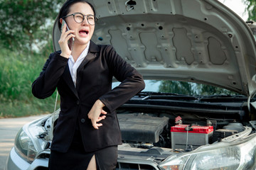 Bussiness women having trouble with broken car feeling stressed. girl using mobile phone calling for help to mechanic for car break down problem. desperate and upset waiting for insurance service.