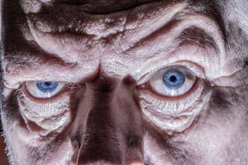 Wall Mural - Close-up of the face of an elderly man. His wrinkled face forms light and shadow.
