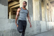 © elnariz - Strong male athlete in sportswear stretching legs, preparing for city jog, urban fitness and exercise