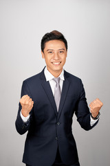 Wall Mural - Happy businessman celebrating his success over white background. Looking at camera