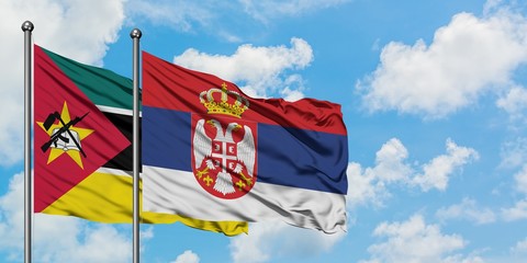 Mozambique and Serbia flag waving in the wind against white cloudy blue sky together. Diplomacy concept, international relations.