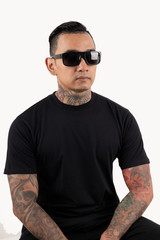 Wall Mural - Tattooed man sitting wearing black t-shirt and sunglasses