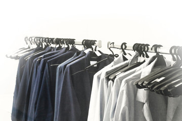 Retro style whitened and a bit noisy clothing background. Blue and white outfit uniform collection hanging on the rack. Blurred. Copy space.