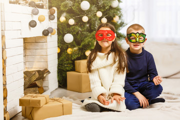 Wall Mural - masked children near the Christmas tree