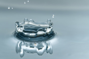 Wall Mural - Beautiful splash of water drop on water surface, macro photo