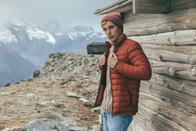 Handsome Male Model Wearing Warm Sweater And Winter Coat Over Mountains With Snow
