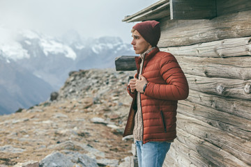 Poster - Handsome male model wearing warm sweater and winter coat over mountains with snow