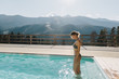 © Alena Ozerova - Young woman spending vacation in swimming pool with mountain landscape