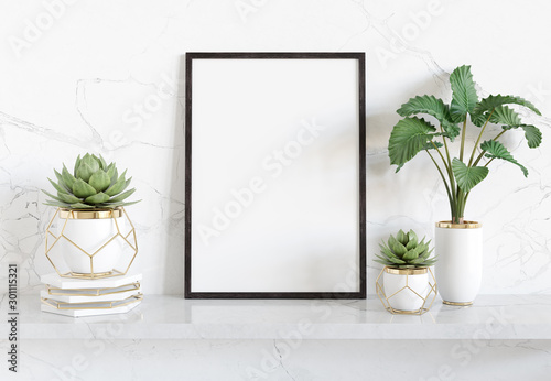 Fotomural Black frame leaning on white shelve in bright interior with plants and decoratio