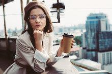 Elegant Pensive Girl In Beige Suit And Beret Posing On Roof With Coffee To Go