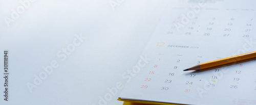 Fotomural close up side view on yellow pencil over white calendar schedule background to