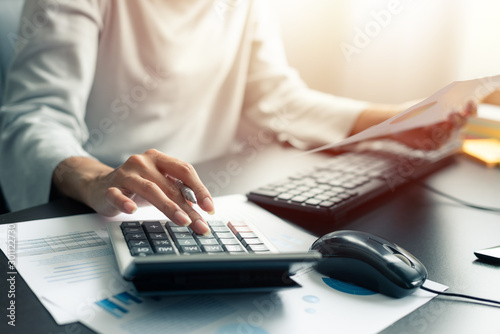 Fotomural Woman accountant or banker use calculator and computer on table at office