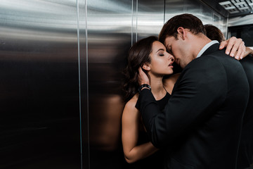 Wall Mural - beautiful passionate couple hugging and going to kiss in lift
