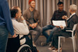 © AnnaStills - Rear view of senior bearded man sitting in wheelchair and listening to people during business meeting
