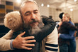 © AnnaStills - Senior bearded man embracing woman and enjoying the hug during therapy with other couple in the background