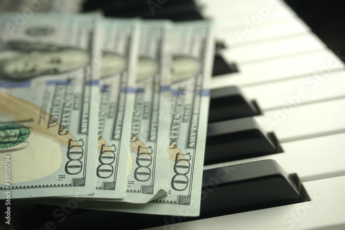 Fotografía one hundred dollars on a piano keyboard close up