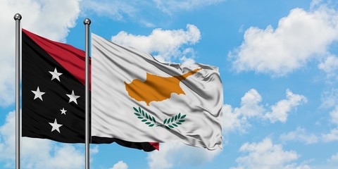 Papua New Guinea and Cyprus flag waving in the wind against white cloudy blue sky together. Diplomacy concept, international relations.