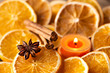 Orange slices, spices and scented candle as Christmas decoration