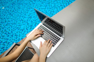 Wall Mural - view from above woman fingers pressing keyboard on laptop sunny