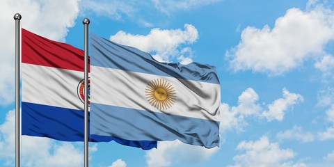 Paraguay and Argentina flag waving in the wind against white cloudy blue sky together. Diplomacy concept, international relations.