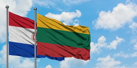 Paraguay and Lithuania flag waving in the wind against white cloudy blue sky together. Diplomacy concept, international relations.