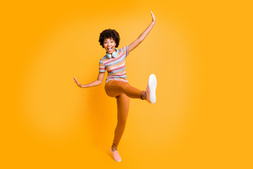 Poster - Full length body size photo of cheerful cute nice positive crazy beautiful girlfriend throwing her leg ahead expressing exciting emotions on face isolated over yellow vivid color background