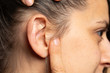Young woman showing pierced ear lobe side view