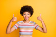 Photo of beautiful dark skin lady holding thumbs raised air expressing agreement and positive attitude wear casual striped t-shirt isolated yellow background