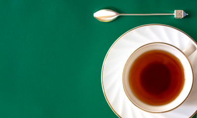 black tea in a Cup and saucer on a green background