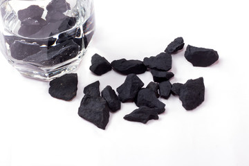 water purified by shungite stones in a glass on a white background