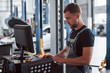 © standret - Professional mechanic. Man at the workshop in uniform use computer for his job for fixing broken car
