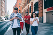 © BullRun - Young people using smartphones during walk with friends