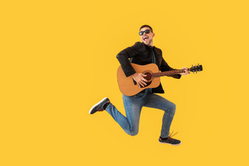 Wall Mural - Jumping man with guitar on color background