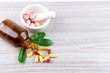 © PhotobyTawat - Natural supplements, vitamin or organic medicine, oil capsule, pill herbal from herbs,herbs leaf in mortar on wooden background, medicine and drug concept