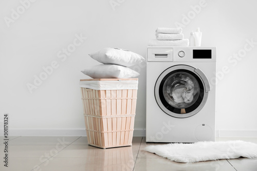 Cuadros en Lienzo Modern washing machine with laundry near light wall