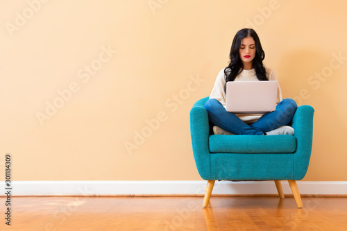 Fotografía Young woman with a laptop computer sitting in a chair