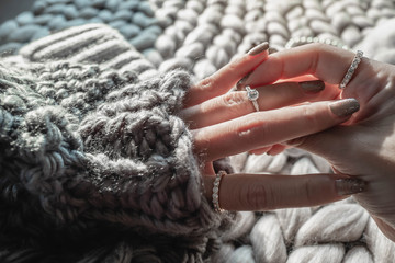 Wall Mural -  Close up of an elegant engagement diamond ring on woman finger with dark gray sweater winter clothe. love and wedding concept.soft and selective focus.