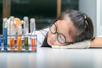 Wall Mural - cute little girl wearing glasses and lab coat making experiment