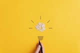Fototapeta Kamienie - Light bulb over yellow background in vision and idea conceptual image