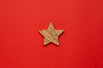 wooden decoration star for christmas tree on red color background
