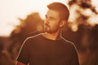 © standret - Confident man standing in the field illuminated by sunlight