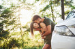 © standret - Front part of white car. Beautiful young couple have a good time in the forest at daytime