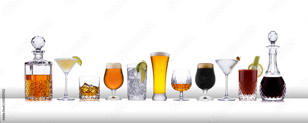 A line of aclcoholic drinks from whisky to lager, in a line, on a white bar like surface - obrazy, fototapety, plakaty 
